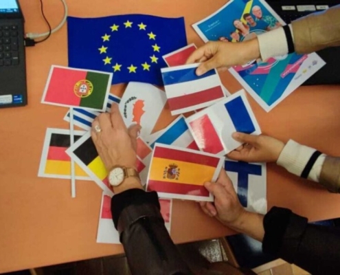 des élèves réorganisent des drapeaux de l'Union Européenne